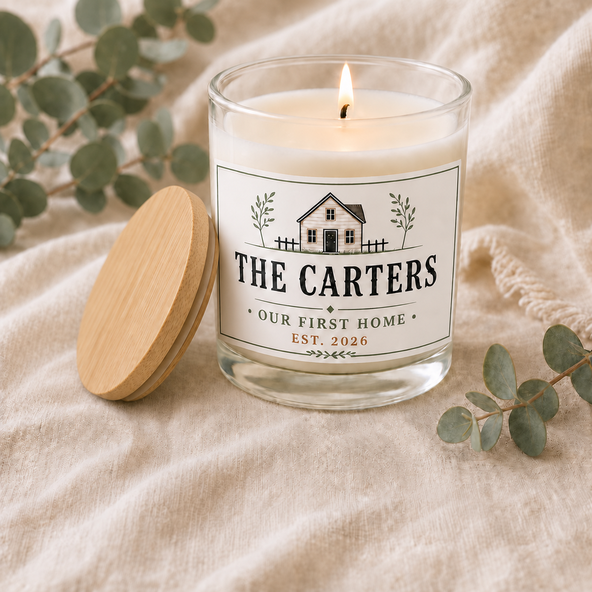 personalized New Home Candle, Custom Family Name Housewarming Gift, lit with natural wood lid beside the jar