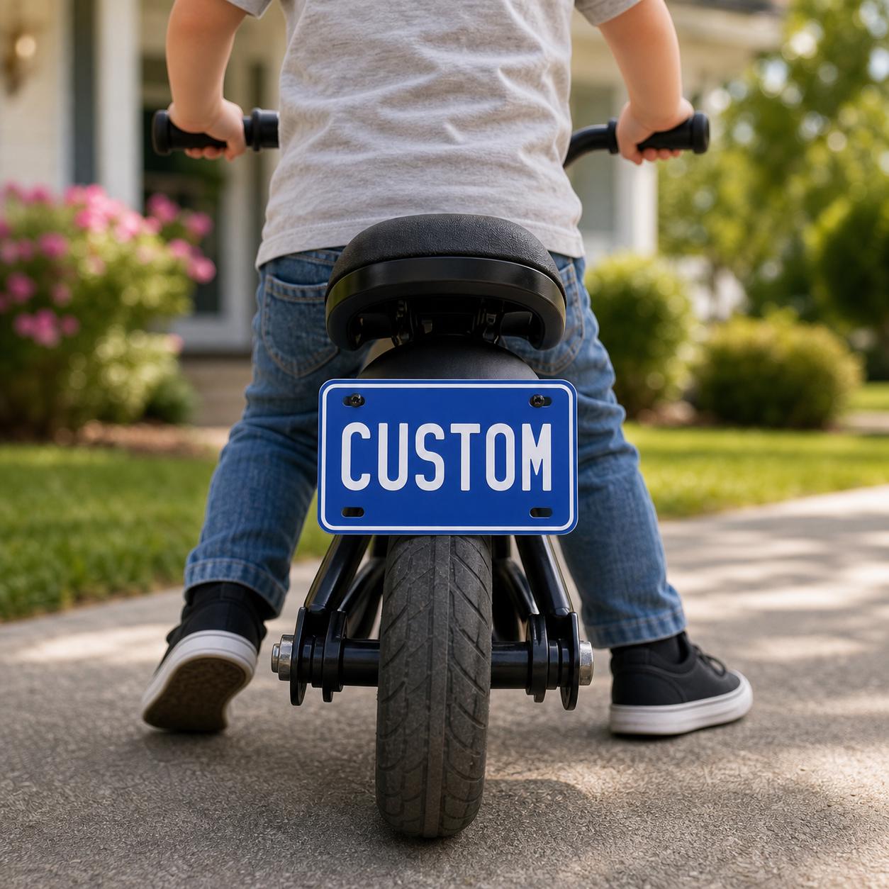 Personalized mini aluminum license plate on a child’s balance bike
