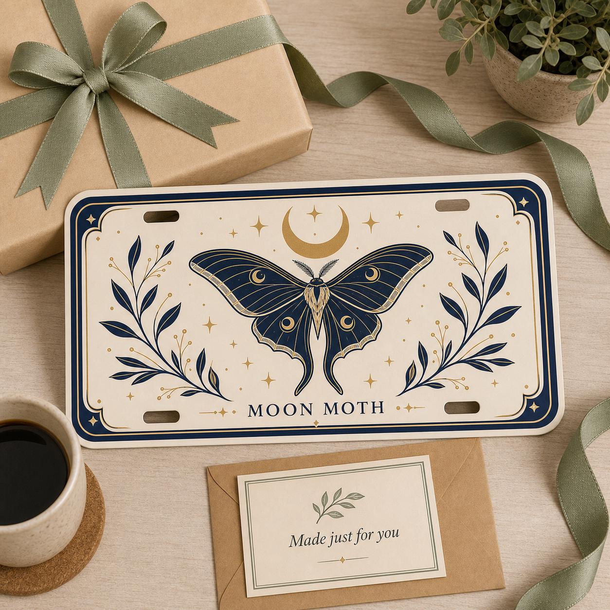 Moon Moth custom license plate in an elegant gift scene with kraft wrapping, sage ribbon, and message card.