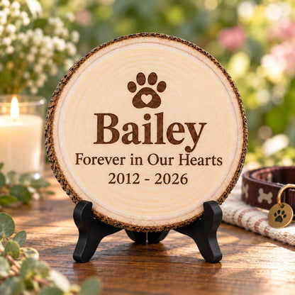 Pet Memorial Wood Slice displayed on the optional black wooden stand in a matching setting. Approved thumbnail September 25, 2026.