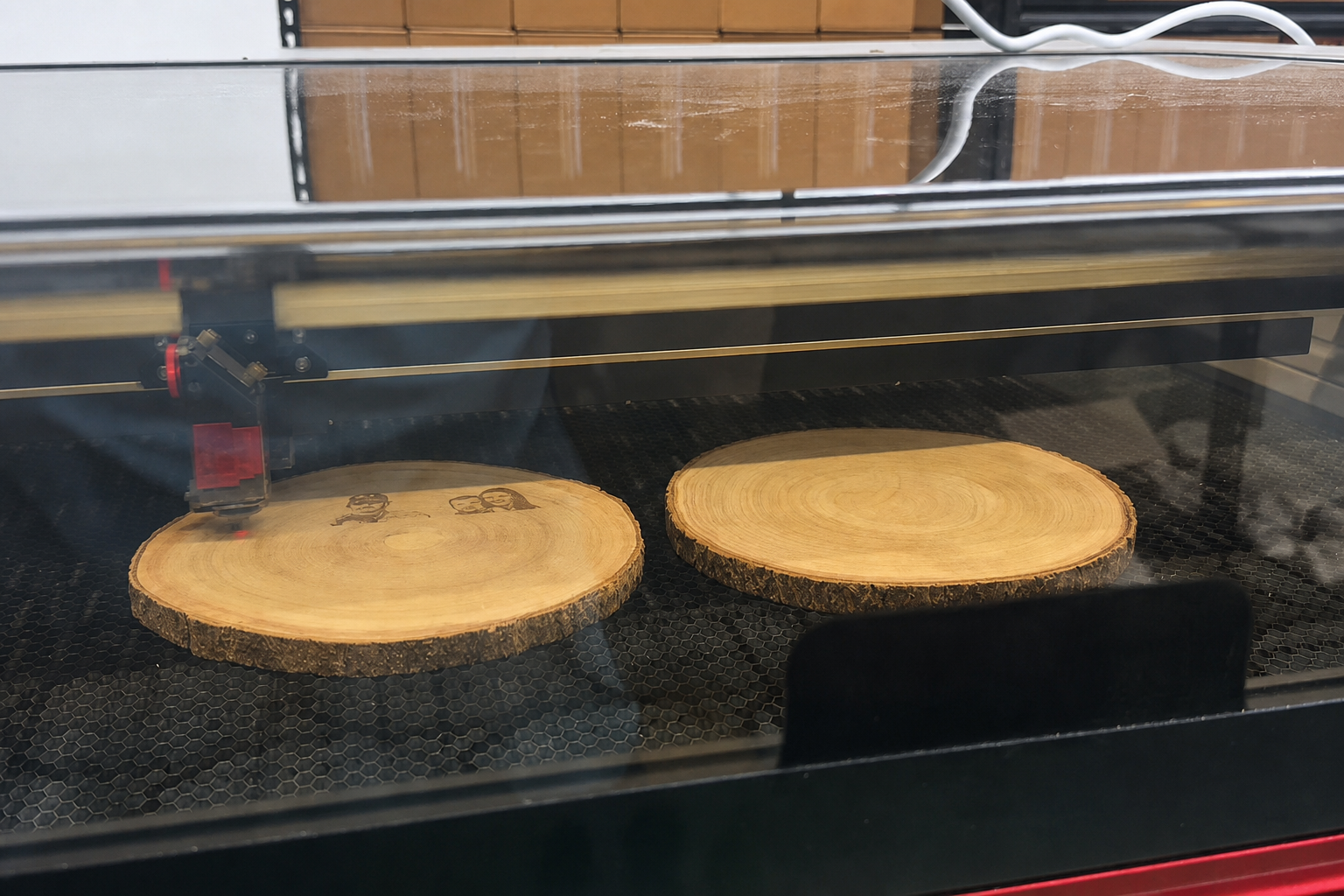 Natural wood slices being engraved inside a MyMaravia laser machine