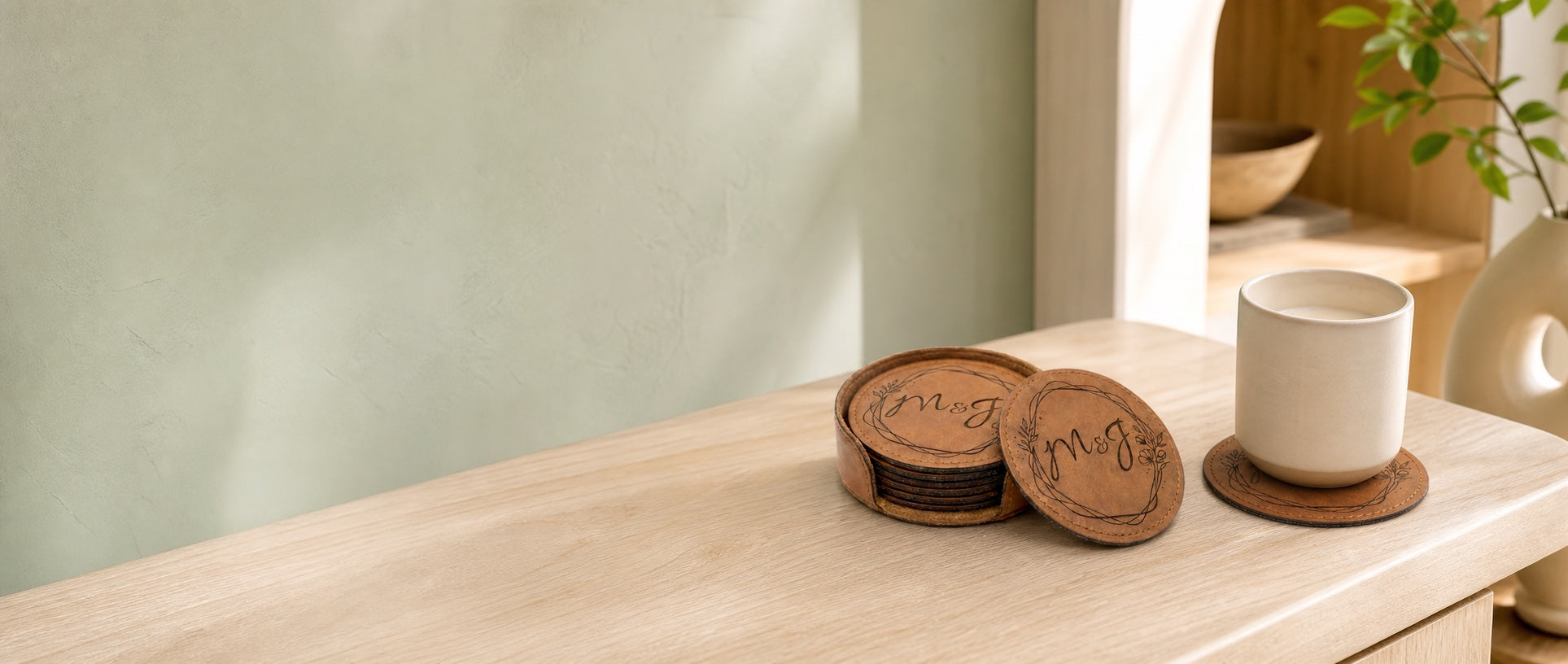 Personalized round leatherette coasters arranged in a holder beside a ceramic cup