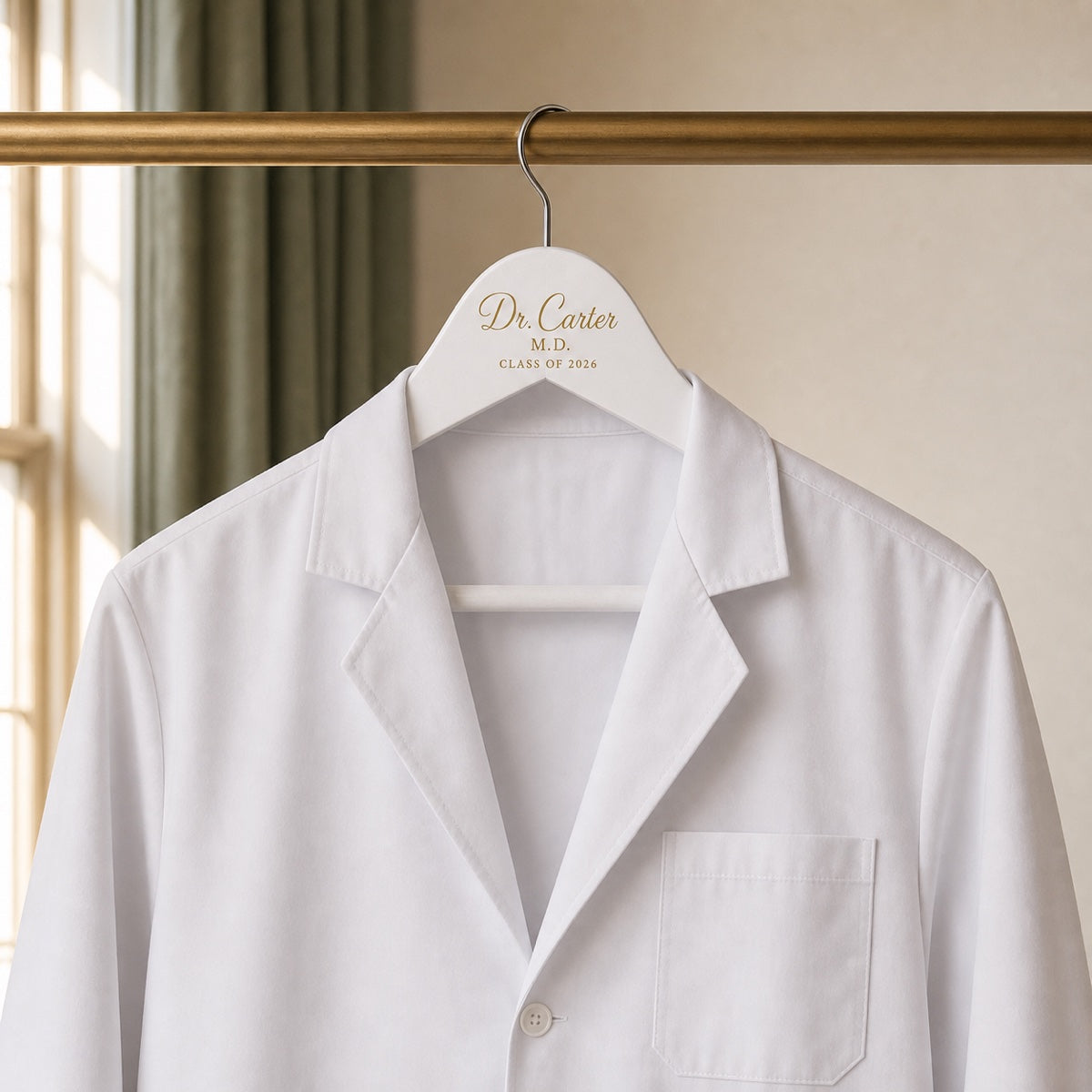 Personalized white coat ceremony hanger holding a white medical coat
