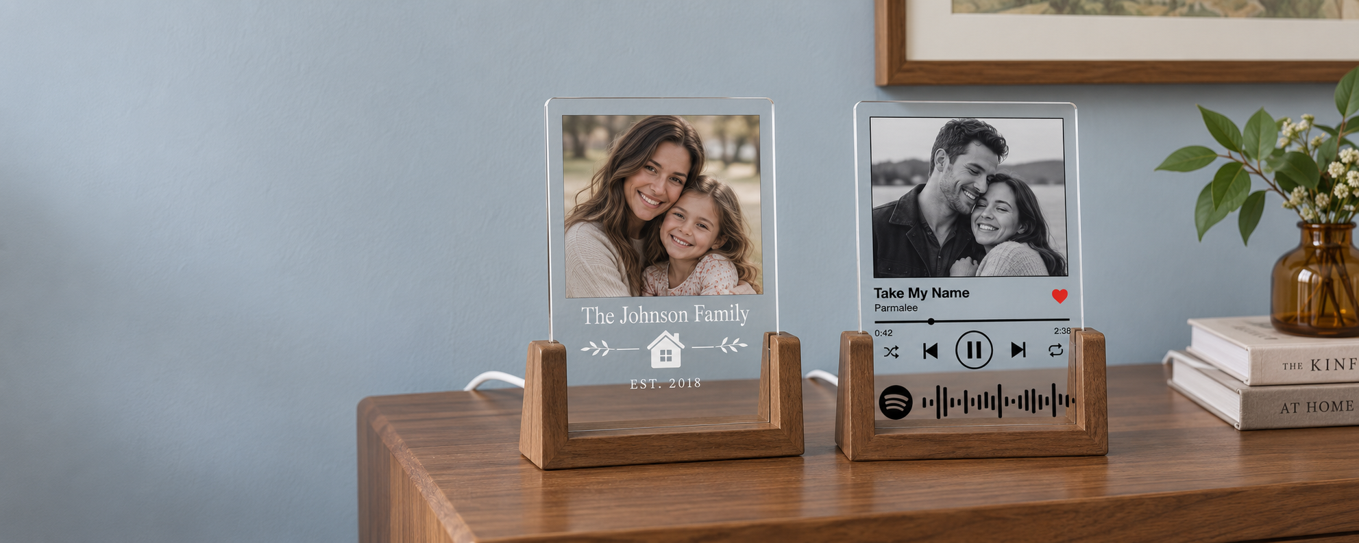 Clear acrylic family and song photo plaques in unlit wooden bases on a walnut console, with a mother and daughter portrait and a couple portrait