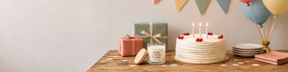Personalized Make a Wish Elaine candle beside a birthday cake, wrapped gifts, balloons and party decorations